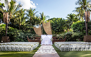An altar arranged in front of a stage surrounded by lush trees