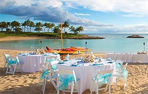Several tables arranged on a beach with a view of the ocean