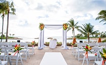 Floral arrangements adorn a wedding altar on a patio overlooking the ocean Floral arrangements adorn a wedding altar on a patio overlooking the ocean