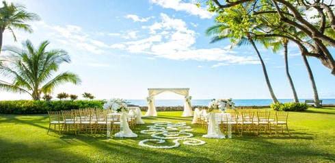 A wedding ceremony area with chairs and a beach view at Aulani Lanikuhonua