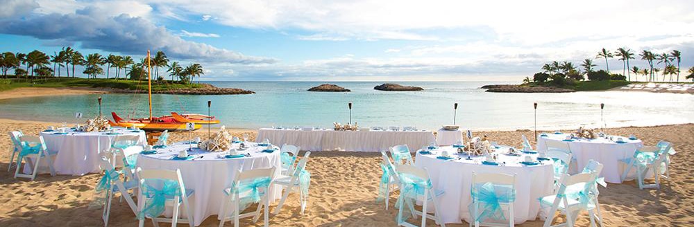 Several tables arranged on a beach with a view of the ocean
