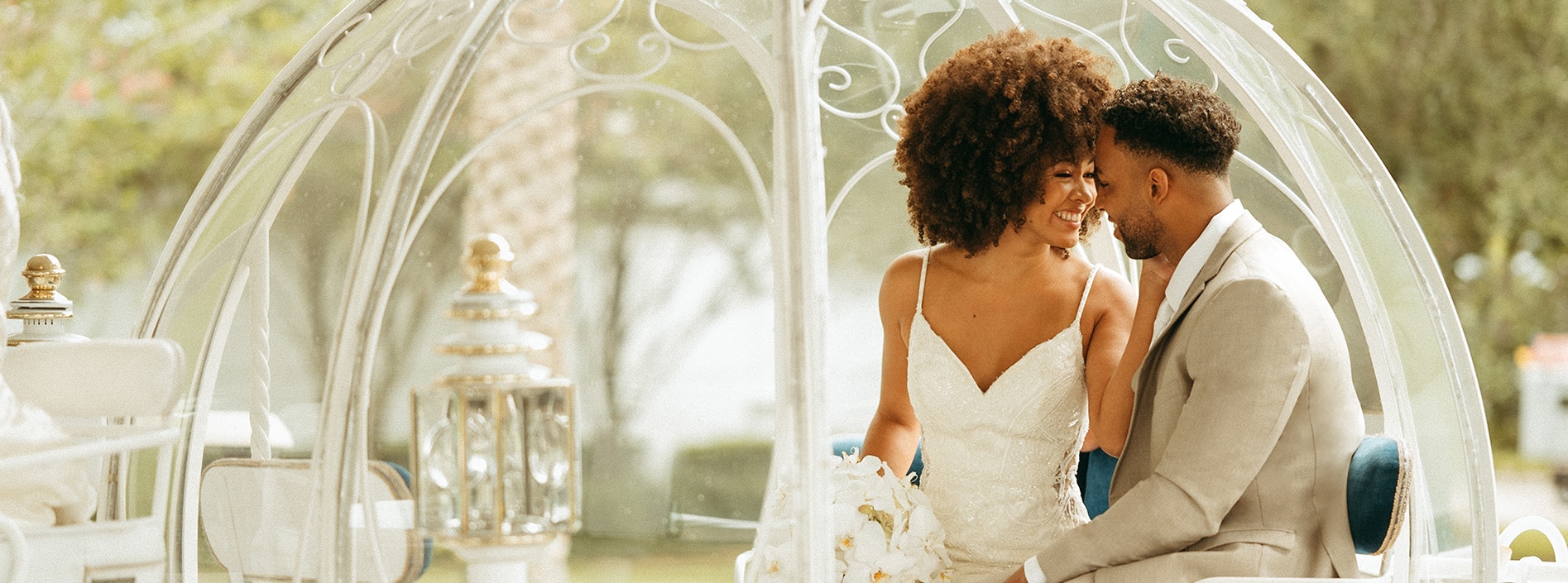 A bride and groom sharing a tender moment inside a Cinderella carriage