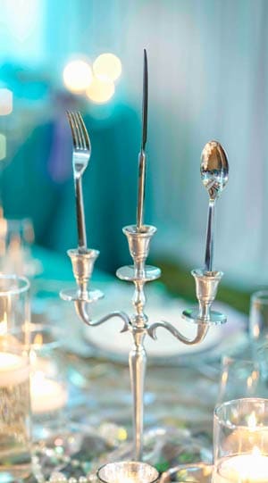 An elegant candelabrum, with a fork, knife and spoon standing upright in its 3 cups An elegant candelabrum, with a fork, knife and spoon standing upright in its 3 cups