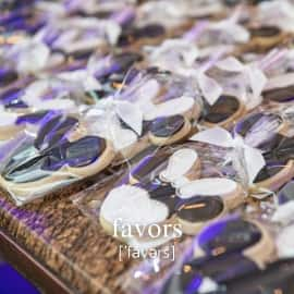 A table filled with wedding favors of individually wrapped cookies in the shape of bride and groom Minnie Mouse and Mickey Mouse ears