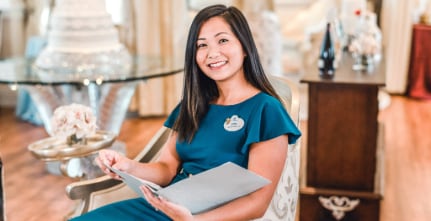 A member of the Disney Fairy Tale Weddings & Honeymoons team holding an information folder during an Open House experience