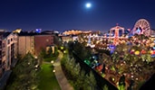 Hotel balconies overlook attractions of Disney California Adventure Park at night
