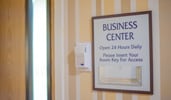 A sign posted on the wall reads Business Center Open 24 Hours Daily