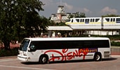 A Disney Transport shuttle bus drives past a monorail track
