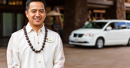 A Cast Member with a kukui nut lei, standing at the entrance to Aulani, A Disney Resort & Spa
