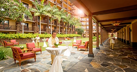 Cast Members preparing a courtyard for an event with chairs and cocktail tables at Aulani, A Disney Resort & Spa
