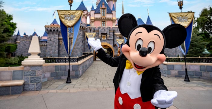 Mickey Mouse standing in front of Sleeping Beauty Castle at the Disneyland Resort
