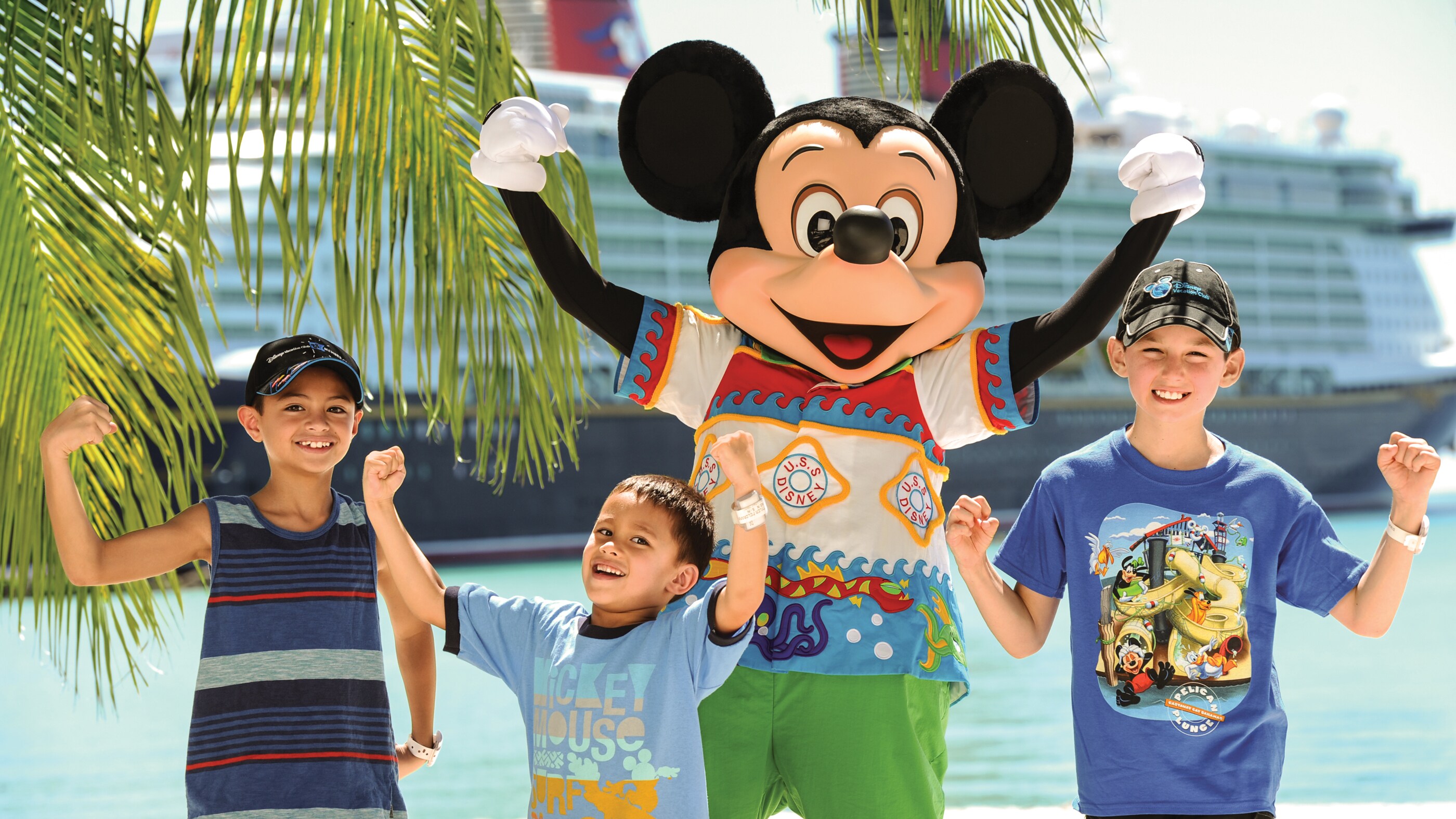 Mickey Mouse flexes his muscles along with 3 of his young fans on the shores of Castaway Cay