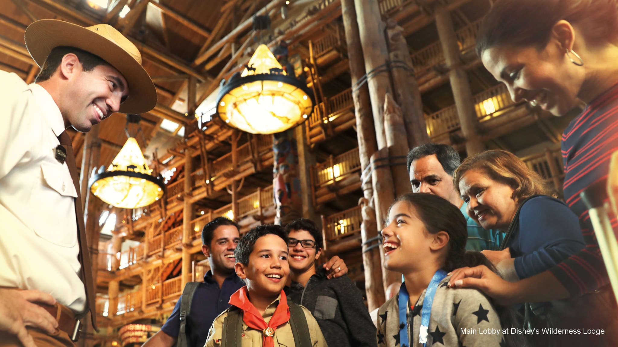 A Cast Member greets a group of 7 Guests in the lobby