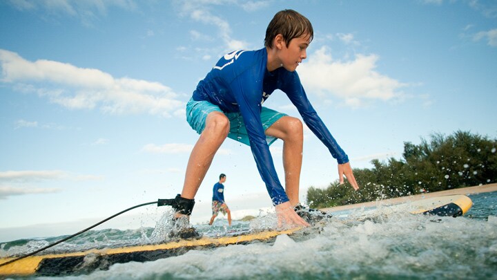 Two boys riding surfboards in calm ocean waters
