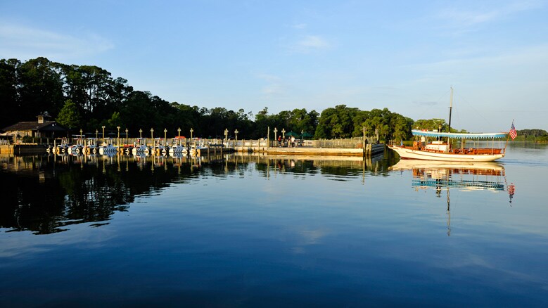 A boat docking at a marina on a lake surrounded by trees