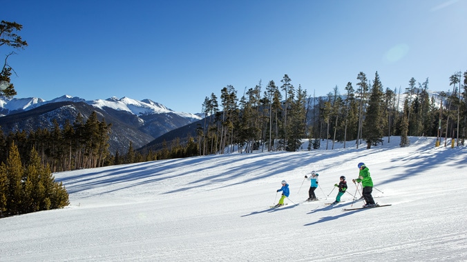 A family snow-skiing down a mountain