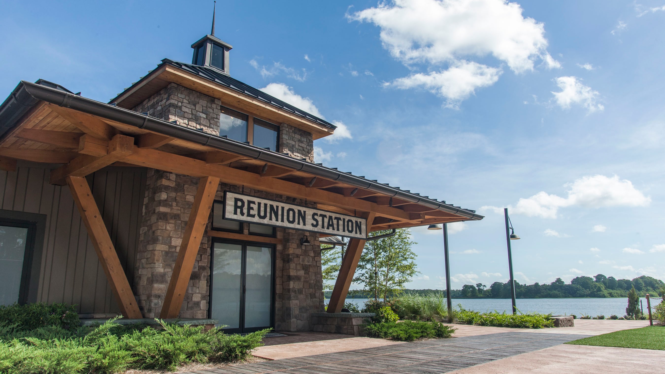 A stone building by a lake, with a sign that reads ‘Reunion Station’