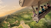A family of 5 seated in a glider above the Great Wall of China