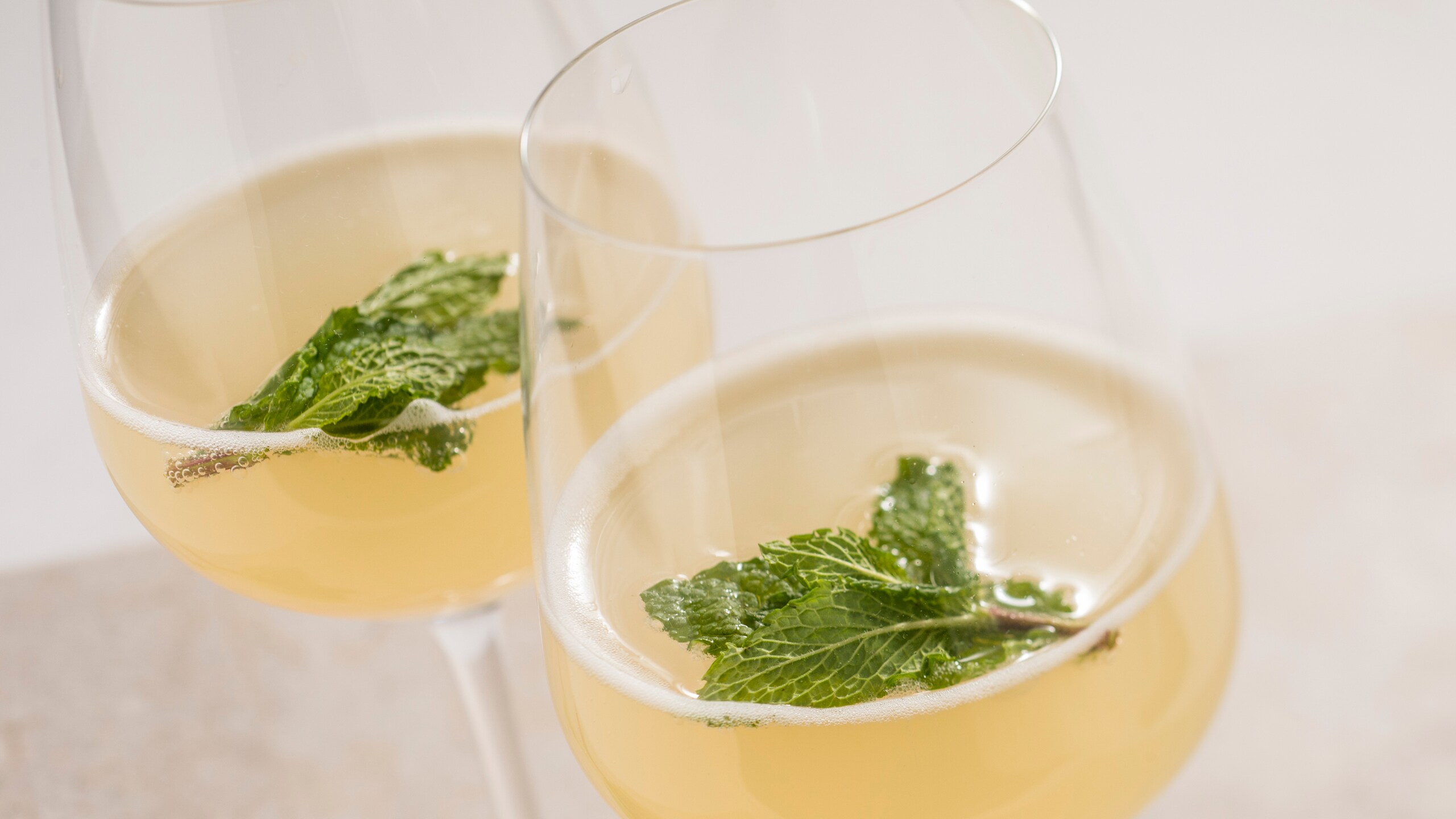 Two cocktails with mint leaves floating inside