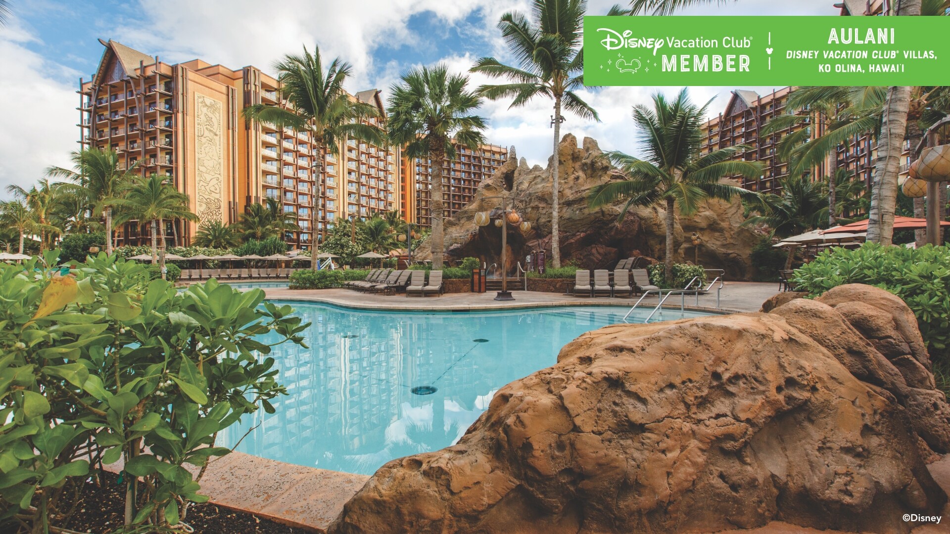 A pool, with some Aulani buildings in the background, over which a banner reads, ‘Disney Vacation Club Member, Aulani Disney Vacation Club Villas, Ko Olina, Hawaii’