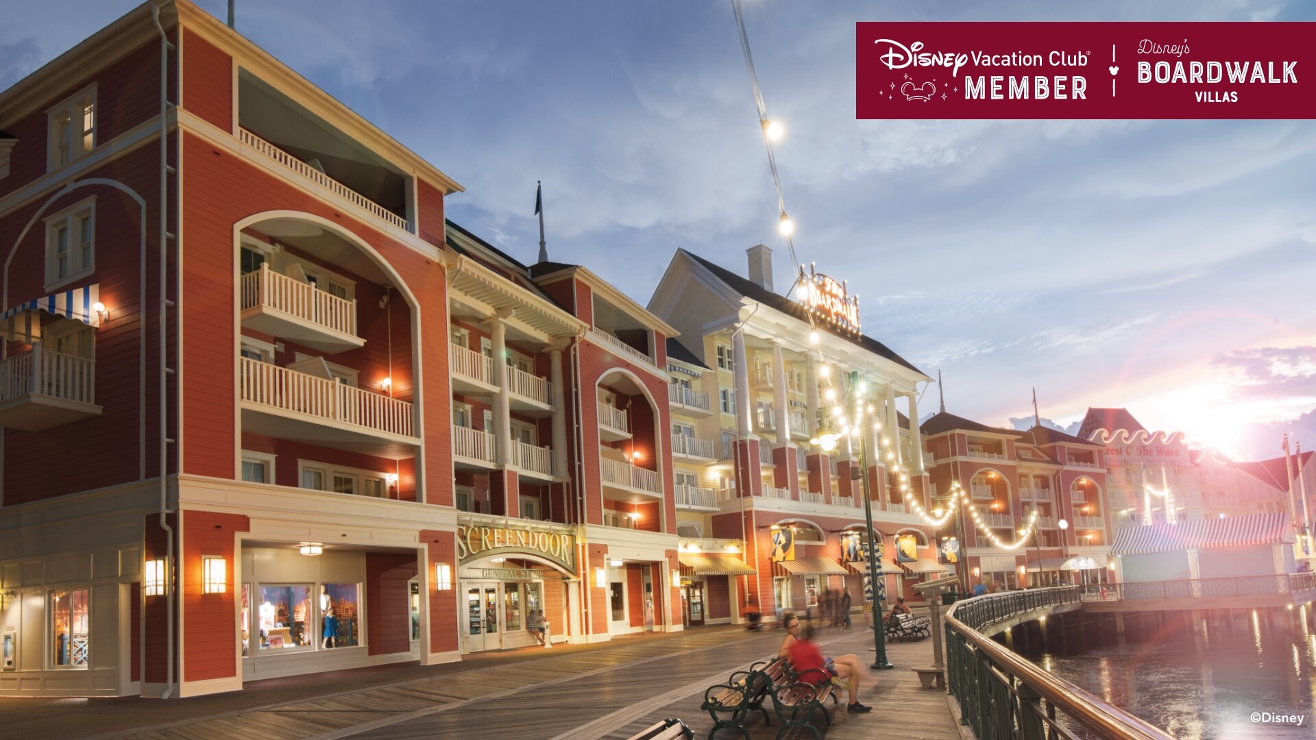 Disney’s BoardWalk Villas and the boardwalk itself, brightly lit at dusk, over which a banner reads, ‘Disney Vacation Club Member, Disney’s BoardWalk Villas’