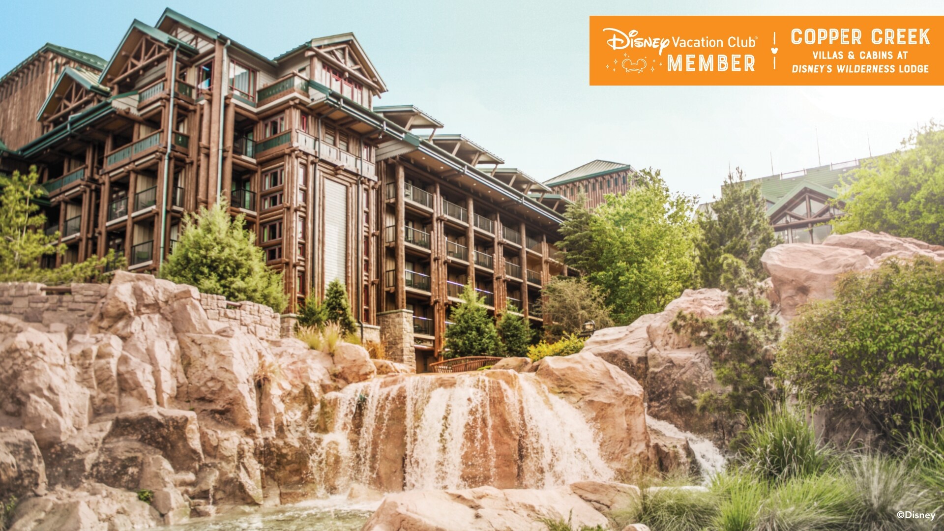 A waterfall over rocks, with the Copper Creek Villas behind it, over which a banner reads, ‘Disney Vacation Club Member, Copper Creek Villas and Cabins at Disney’s Wilderness Lodge