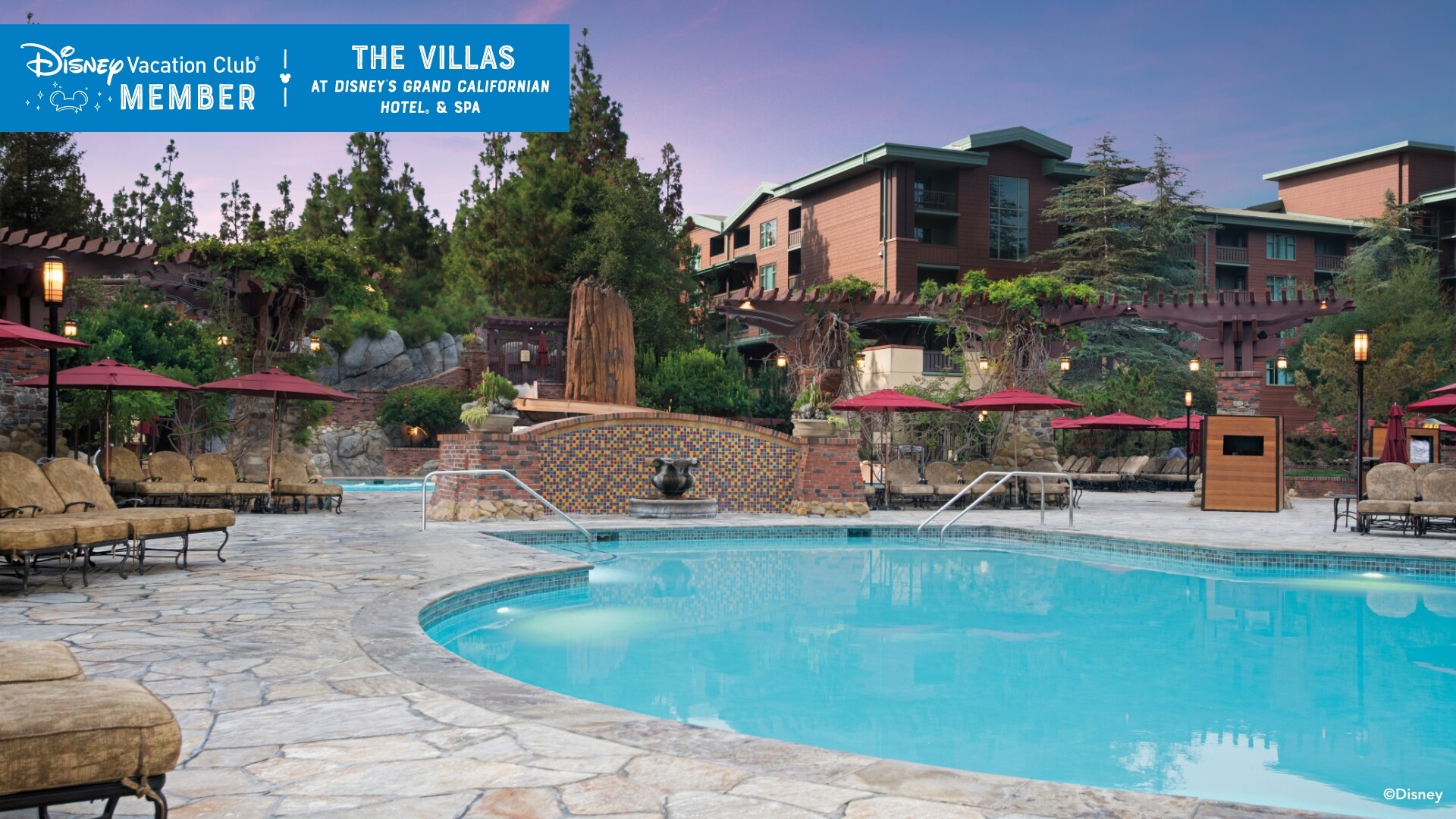 A pool, with Villas in the background, over which a banner reads, ‘Disney Vacation Club Member, The Villas at Disney’s Grand Californian Hotel and Spa’
