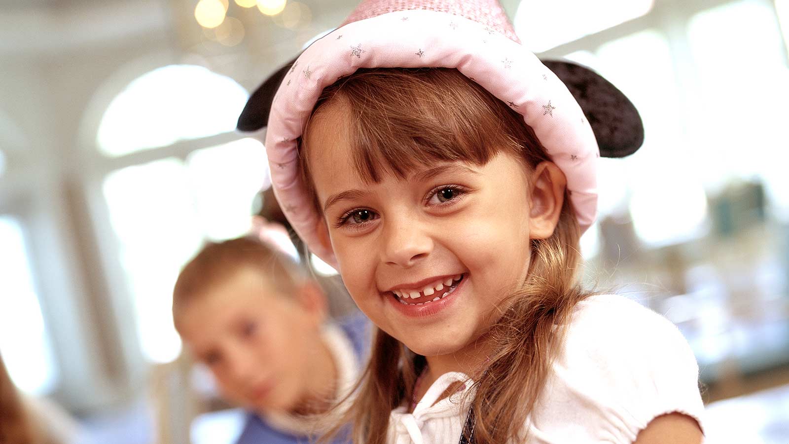 A young girl wearing a hat and smiling
