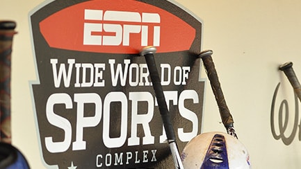 Four baseball bats by a sign that reads "ESPN Wide World of Sports Complex"
