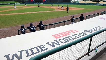 Several baseball players on a field, by a banner that reads "ESPN Wide World of Sports Complex"