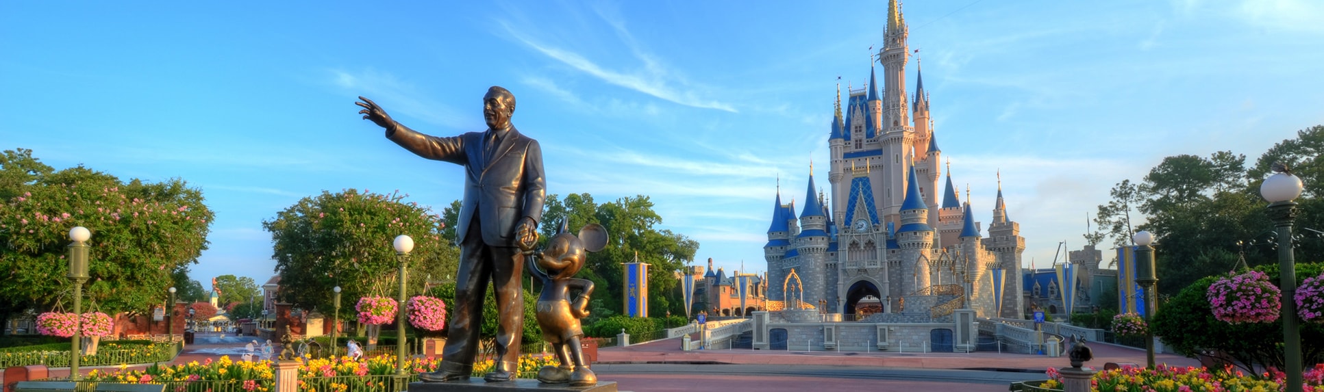 A statue of Mickey Mouse and Walt Disney holding hands in front of Cinderella Castle at Magic Kingdom park