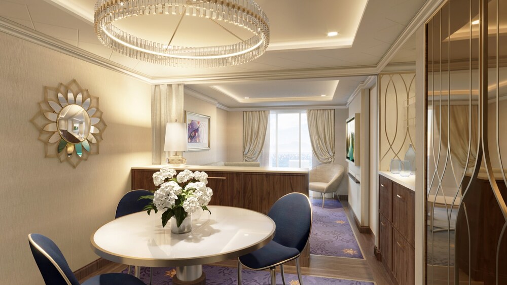 An artist rendering of a Disney Wish Concierge One Bedroom Suite with Verandah living room featuring a closet, mirror, sofa, chair, artwork inspired by Tangled, dining table with chairs and a verandah facing the ocean