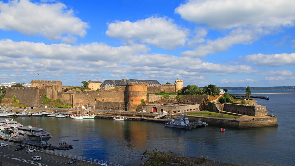 A marina with boats near castle walls and a mansion