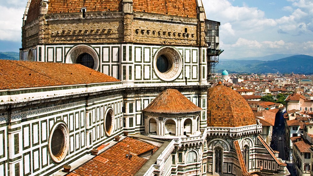 Shingled building with circular windows and domed roofs and ornamental patterns on the walls