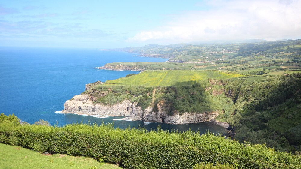 A town sits on a crescent shaped peninsula with mountains in the background
