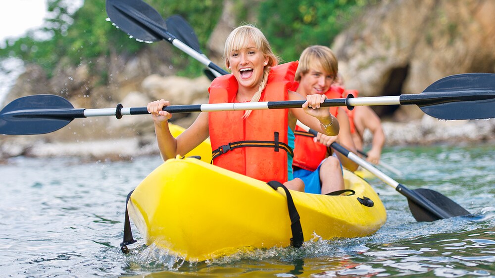 Smiling woman and man in a kayak paddling
