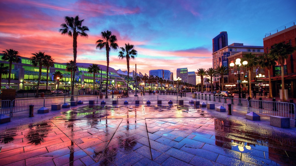 Palm trees and parking barricades in front of a modern looking shopping area at sunset