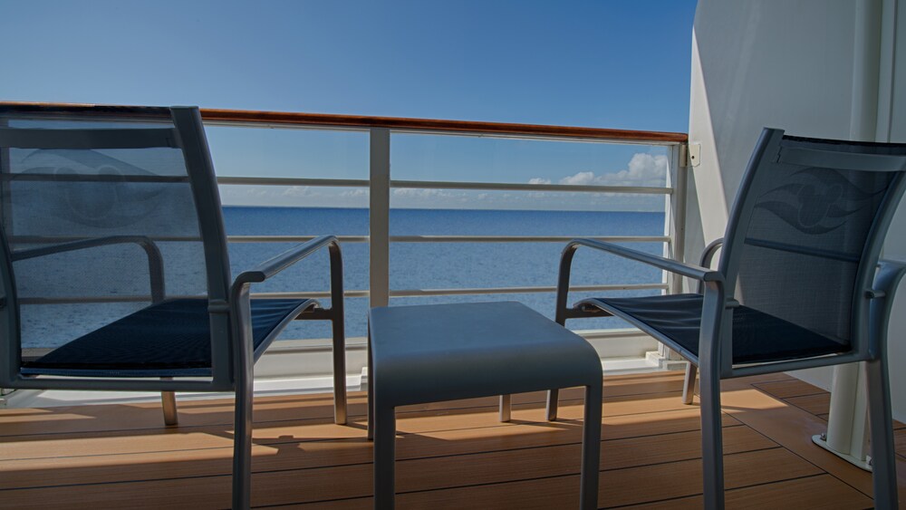 Two chairs and a table on a verandah facing the ocean