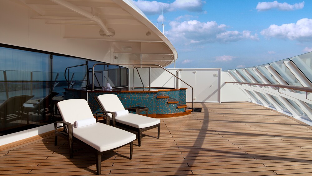 A verandah with an ocean view, 2 lounge chairs and a whirlpool in a Disney Cruise Line Concierge Royal Suite with Verandah Stateroom 