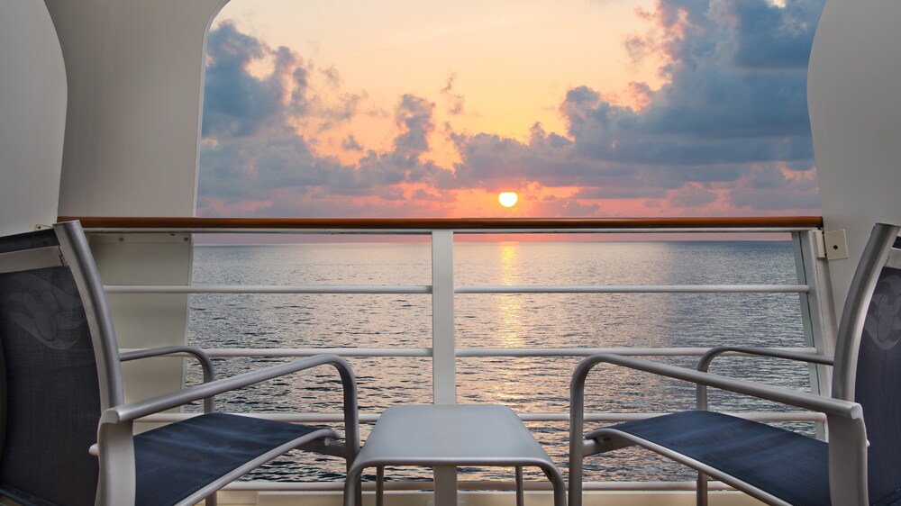 Two chairs and a table on a verandah facing the ocean