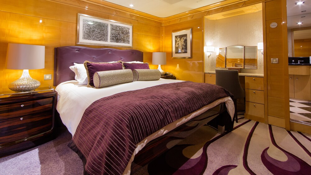 A Disney Cruise Line Concierge Royal Suite with Verandah bedroom with a bed, vanity and 2 nightstands