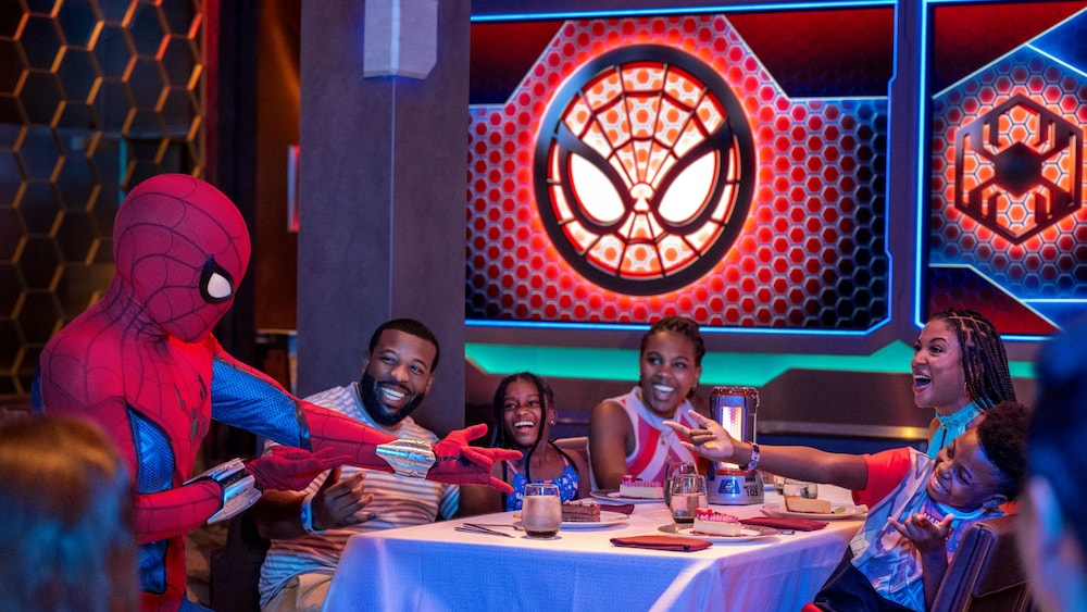 A family laughs with Spider Man at Worlds of Marvel