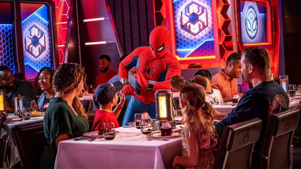 Spider-Man giving a young boy dining in a restaurant with his family a high five