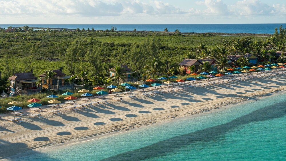 Serenity Bay beach with umbrellas and cabanas