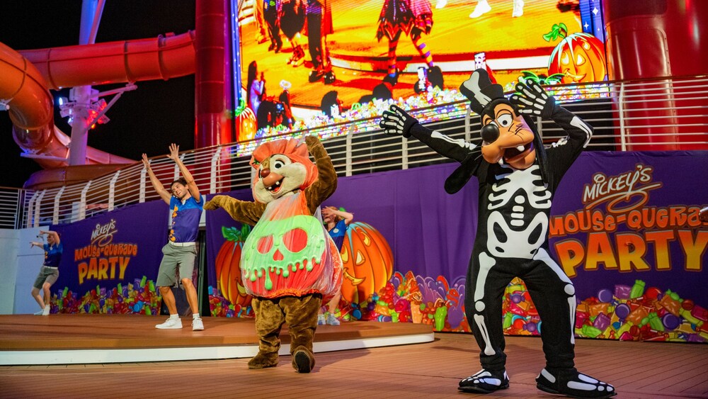 One of the Chip and Dale chipmunks dressed as a jack o lantern and Goofy in a skeleton costume performing during Mickey's Mouse-Querade Party