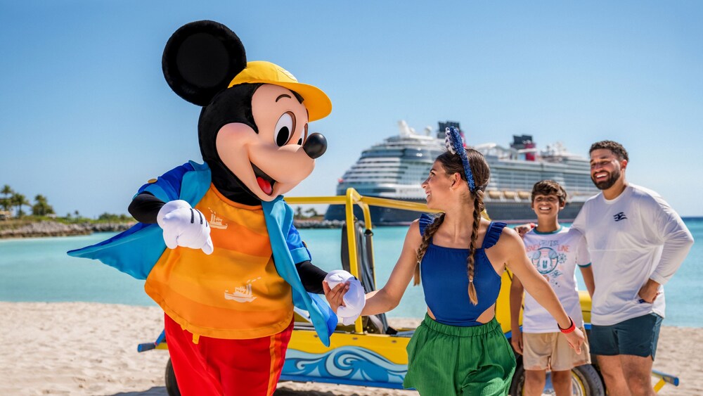 Mickey Mouse holding hands with a Guest on a beach with a docked Disney Cruise Line ship