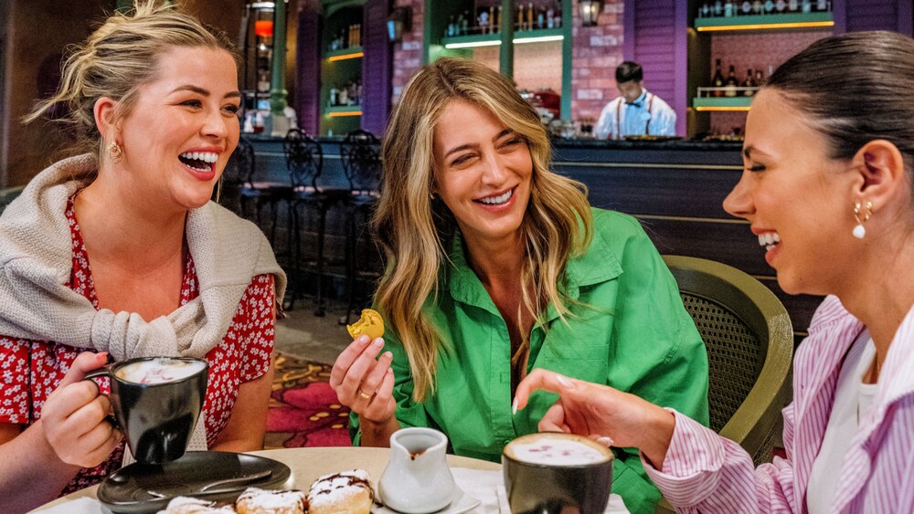 Three female Guests enjoying drinks and beignets at the French Quarter Lounge