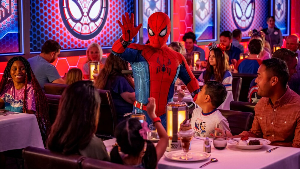Spider Man saluant des clients attablés au Worlds of Marvel