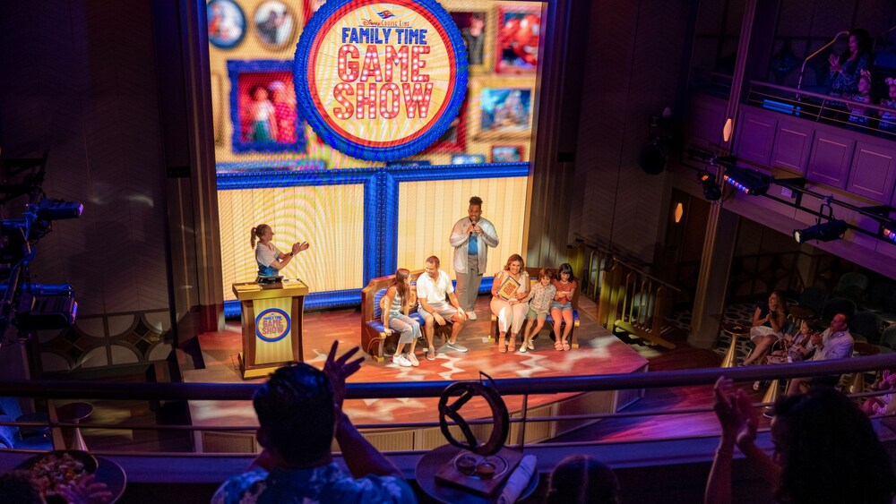 Pasajeros en el escenario participando en el concurso Family Time Game Show de Disney Cruise Line