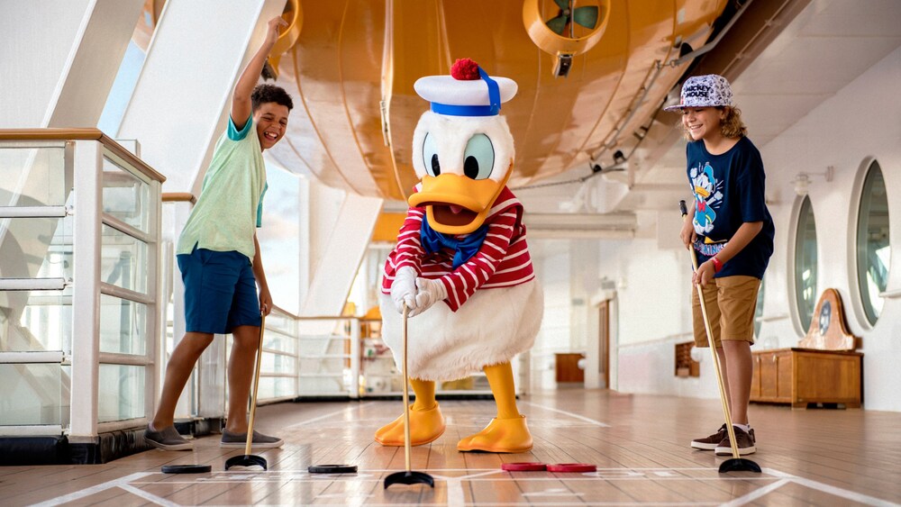 Niños jugando con el Pato Donald Marinero en la cubierta del Disney Dream